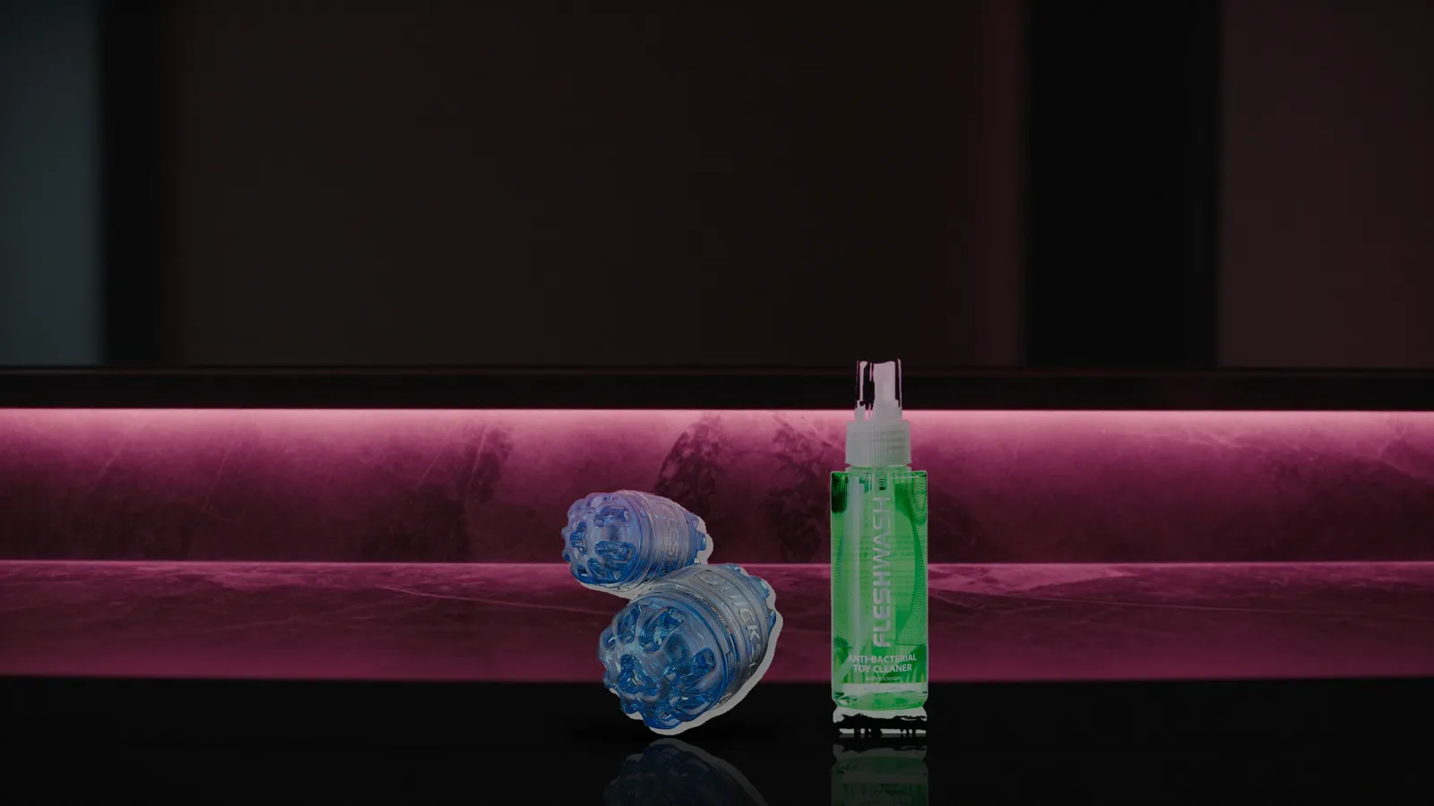 Quickshot Turbo and Fleshwash bottle on a dark marble shelf lit by pink neon