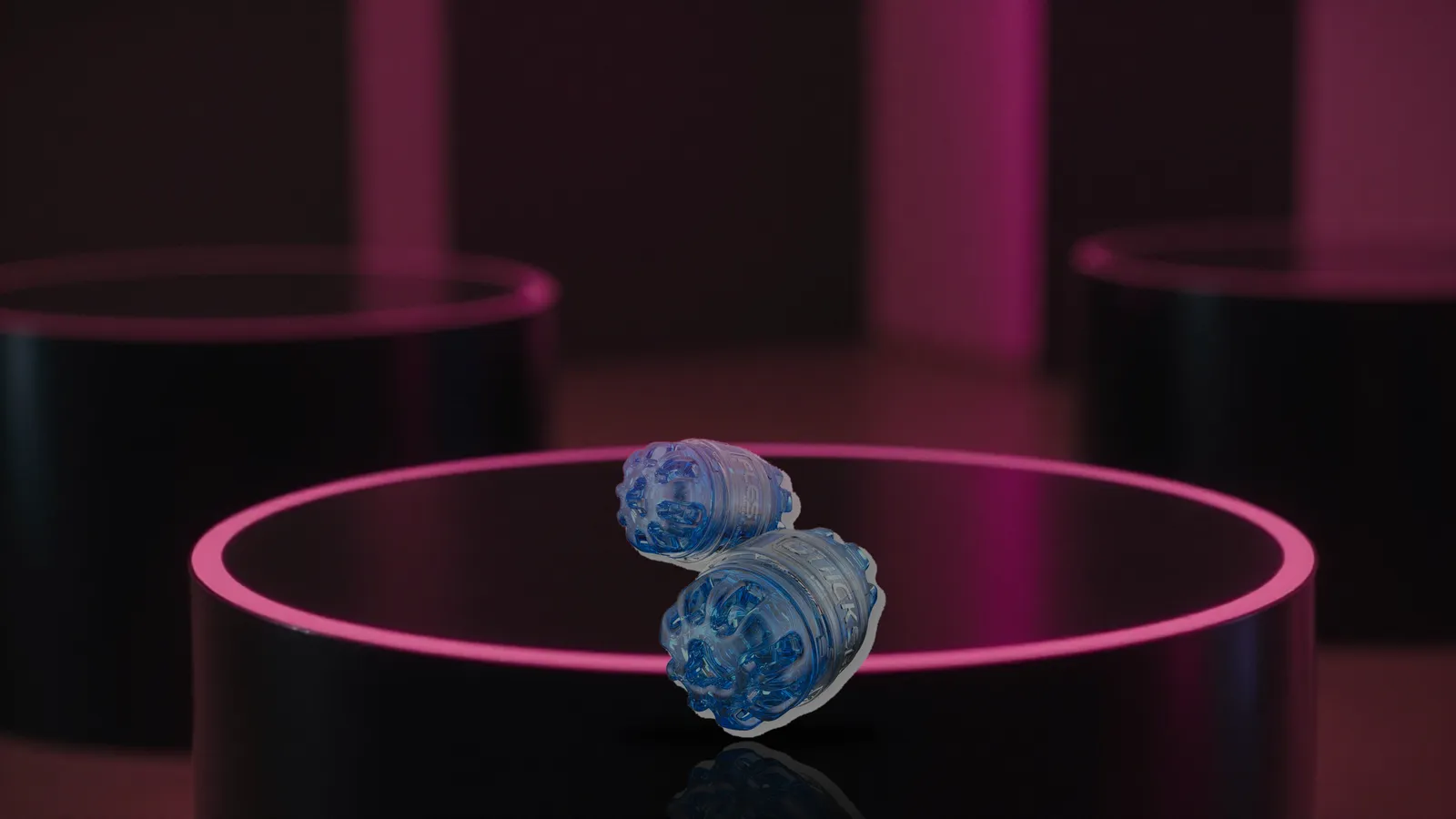 Quickshot Turbo on a glossy black pedestal with shallow depth of field and pink rim light
