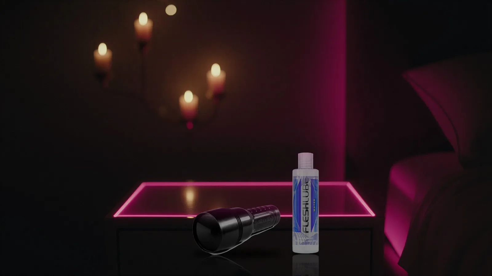 Closed black Fleshlight case and Fleshlube Water on a dark bedside table