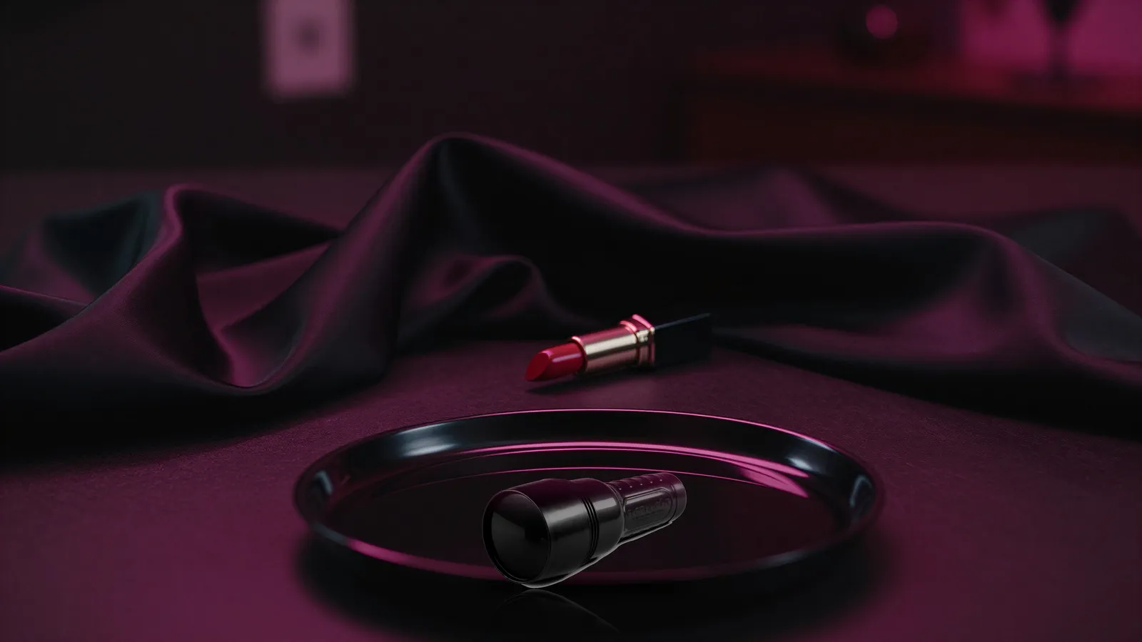 Closed black Fleshlight case on black satin beside an unbranded red lipstick under pink light