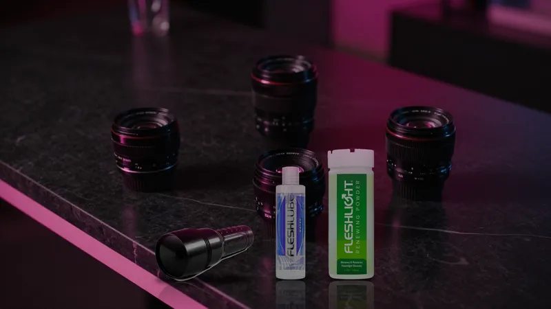Closed Fleshlight case, Fleshlube Water, and Renewing Powder arranged on black marble