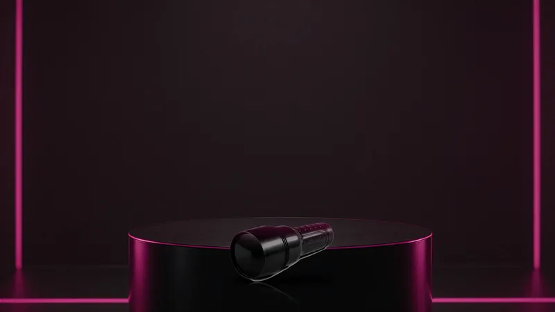Closed black Fleshlight case on a minimal glossy pedestal under a tight spotlight